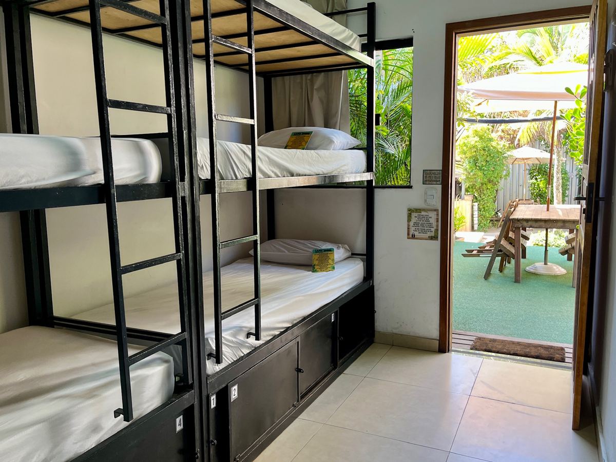 Quarto compartilhado com beliches triplos e porta para o jardim